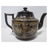 Brown ceramic teapot with ornate design