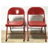 Two red metal folding chairs