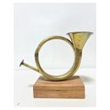 Metal trumpet art piece on wood block