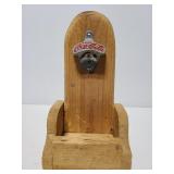 Vintage metal Coca-Cola bottle opener on wood