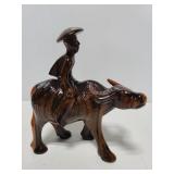 Carved wood man riding bull figure