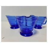 Three blue glass creamers