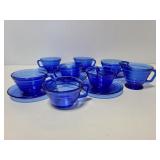 Blue glass teacups and saucers with creamer