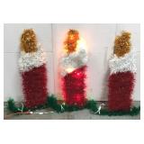 Three lighted outdoor Christmas candles