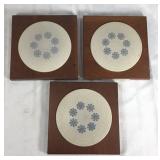 Trio of ceramic and wood trivets