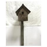 Wood birdhouse on tall stake