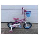 Pink bike with basket and training wheels