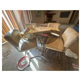 Glass-top dining table with metal base and four