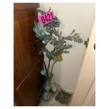 Artificial floral arrangement in glass floor vase