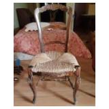 Wooden chair with designs engraved throughout along with woven seating