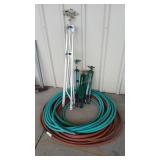 2 GARDEN HOSES AND 4 TRIPOD SPRINKLERS