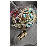 Costume jewelry and beads in plastic footed bowl