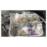 Tin of costume jewelry