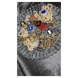 Glass platter with vintage brooches, beads and