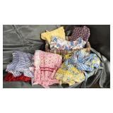 Vintage home made aprons and bonnets in basket