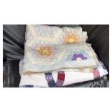 Old tattered hand made flower quilt and bedspread