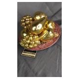 Gold tone fruit on red and white plate
