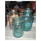 2 blue fruit jars and jar of wooden spools