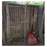 Metal Gate, Chain-Link Roll, and Gas Cans