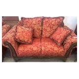 Red Patterned Loveseat With Carved Wood Accents
