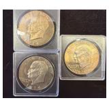 Three Eisenhower Dollar Coins in Plastic Cases