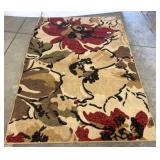 Rolled Area Rug With Red Floral Pattern
