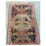 Worn Wool Rug and Straw Hat With Ribbon Trim