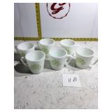 Six white Pyrex coffee mugs with green leaves