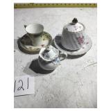 Two sugar bowls a saucer in a cup and saucer
