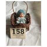 Doll in wicker carriage