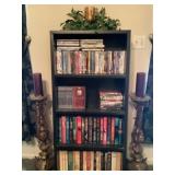 Black bookshelf with assorted CDs, assorted b