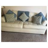 Leather like couch with throw pillows and blanket
