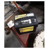 NAPA Sure-Start 65 battery and wheeled stool.