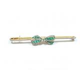 unmkd yg pin with green stones and a diamond chip