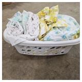 Various Floral Bedding in White Laundry Basket