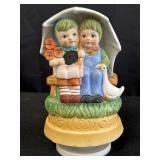 Porcelain music box w/ two children under umbrella