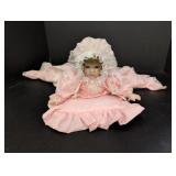 Porcelain Baby Doll lying on pillow marked Mann