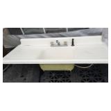 Kitchen sink with side grooved panels, faucet and