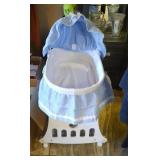 blue and white bassinet on wheels with sun cover