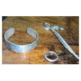 Unmarked cuff bracelet, ring, feather bookmark