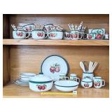 Group of matching apple dishes including cups,