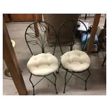 Two metal chairs with cushions