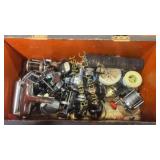 Box full of fishing reels and assorted tackle