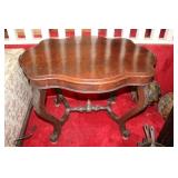 Walnut style table with leaf carvings on the legs