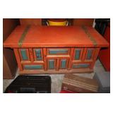 Orange wooden decorated trunk and a knee hole