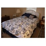 Full size white wicker bed with linens and