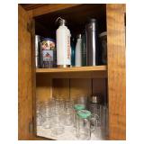 Upper cabinet contents over bar including glasses,