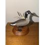 Miniature goose carving standing by reeds on a