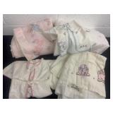 Group of crib sheets and baby clothes