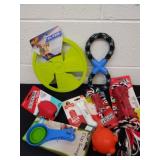 Large group of dog toys, bones, and a Frisbee
